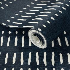 a black and white tie with an interesting pattern on it's side, next to a roll of tape