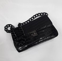 An elegant classic style bag with a strong scent of the legendary original designs that marked deeply the modern fashion, made of high quality genuine greek calf leather, processed properly in order to resemble croc leather. The bag's inner space is seperated in three (3) divisions, as also a zipped pocket is included. The chain is made of black nickel and it's proper for the use of the bag as a Shoulder Bag. The bag includes a safety lock, which can be opened simply via sliding the small round Black Luxury Square Baguette Bag, Luxury Black Square Baguette Bag, Luxury Square Clutch For Everyday, Trendy Textured Leather Formal Bag, Chic Leather Baguette Bag With Chain Strap, Luxury Square Clutch For Office, Elegant Faux Leather Bag For Office, Elegant Textured Leather Box Bag, Elegant Faux Leather Office Bag