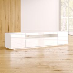 a white entertainment center in an empty room with wood flooring and large sliding glass doors