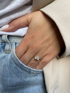 a woman's hand with a diamond ring on her left wrist, in jeans