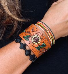 "Mod pop flowers leather bracelet. This is a cute and fun hand tooled and hand painted leather bracelet Please note each one of these is handmade so no two are exactly alike. Material Vegetable Tan leather Acrylic paint metal hardware Size 1.5\" width Please state wrist size when ordering. Please note each one of these is handmade so no two are exactly alike. Please allow 10 - 15 business days for manufacture of item, excluding shipping time. Shipping times vary and are beyond our ability to con Bohemian Leather Bracelet For Gift, Bohemian Leather Bracelet Gift, Hand Tooled Leather Bracelets For Festivals, Hand Tooled Adjustable Leather Bracelets, Handmade Multicolor Leather Bracelets, Handmade Bohemian Flower Cuff Bracelet, Bohemian Flower Cuff Bracelet Handmade, Artisan Hand Wrapped Leather Bracelet, Artisan Hand-wrapped Leather Bracelet