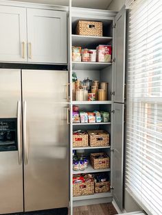 a kitchen with stainless steel refrigerator and pantry shelving