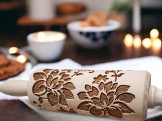 a wooden rolling pin sitting on top of a table next to crackers and cookies