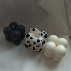 three black and white balloons sitting next to each other