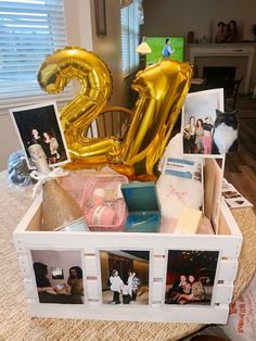 an open box filled with photos and balloons in the shape of the number twenty two