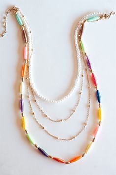 Add a pop of color to your jewelry collection with the Sam Multicolored Layering Necklace. This beautiful necklace features delicate gold chains, accented with lustrous pearls and a mix of vibrant elongated beads. The high-quality materials and attention to detail make this necklace both durable and stylish, making it a perfect choice for any occasion. Wear it alone as a statement piece or layer it with other necklaces for a personalized and on-trend look. Whether you're dressing up for a specia Summer Necklaces, Necklace Gold Chain, Necklace Colorful, Summer Necklace, Gold Necklace Layered, Layering Necklace, Colourful Necklace, Beautiful Necklace, Gold Chain Necklace