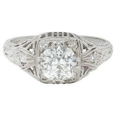 an antique style diamond ring with filigrees on the sides and center stone