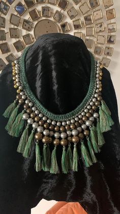 Complement your personality with this boho-chic trendy unique necklace. Our skilled Indian craftsmen beautifully handcraft the gorgeous necklace with green threads, and silver and gold beads weaved together to make a stunning piece. Light weight necklace Drop length of necklace: approximately 9 inches Comes with a lobster claw closure Adjustable Length Green Macrame Jewelry For Festival, Green Macrame Jewelry For Festivals, Green Macrame Hippie Jewelry, Handmade Green Bohemian Beaded Necklaces, Hippie Green Jewelry With Colorful Beads, Hippie Style Green Beaded Necklace For Festivals, Green Hippie Festival Jewelry, Hippie Green Festival Jewelry, Green Macrame Necklace For Festivals