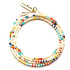 Ivory glass seed beads with stripes and 14k gold filled accents. The pieces can be worn as a wrap bracelet, necklace, or anklet. Measures 27". White Multi-strand Bracelets With Colorful Beads, White Wrap Bracelet With Colorful Beads As Gift, White Wrap Bracelet With Colorful Beads For Gift, Adjustable Single Strand White Beads, White Multi-strand Beaded Bracelets As Gift, White Heishi Beads Single Strand Jewelry, White Bohemian Wrap Bracelet With Tiny Beads, Bohemian White Wrap Bracelet With Tiny Beads, Adjustable White Hand-strung Wrap Bracelet