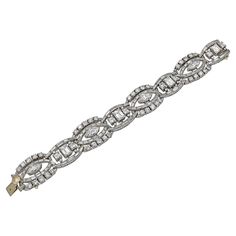 When baguette diamonds—those linear, sleek, rectangular fancy cut stones that reached their height of popularity in the 1920s—are used to deftly drive the dynamic movement within a jewelry composition, it borders on pure poetry. This Vintage Diamond Articulated Bracelet is made in the middle of the XX century, circa 1960s, however, it certainly demonstrates a dexterity and technical prowess associated with multiple glorious jewelry periods from the last two centuries. Crafted in 18K white gold, the bracelet features baguette-, emerald-, round brilliant-, and marquise-cut white diamonds with an estimated total weight of 38.00 carats. The diamonds are not certified and are equivalent to D-F color and VS clarity. Within the 6.63-inch long (16.84 cm) bracelet, lyrical fluid lines of baguette d Jewelry Composition, Vintage Jewelry 1920, Vintage Diamond Bracelet, Diamond Gold Bracelet, Dynamic Movement, Bracelet Tennis, Bracelets Design, Baguette Diamonds, Baguette Cut Diamond