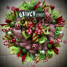 a christmas wreath with candy canes and candies on the front door for grin street