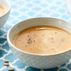 there is a bowl of soup on the table next to two small bowls with food in them