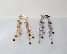 "more cute and fun necklaces and earrings in DearDanielleJewelry: https://www.etsy.com/shop/DearDanielleJewelry?ref=seller-platform-mcnav§ion_id=28417638 Shooting Star Earrings,Celestial Dangle Earrings. Star cascade, Star fall earring. Gold starry. Tiny sparkling little stars. 5/8\" diameter hammered gold plate star, 3\" drop Please choose your star color : Gold. Silver **framed gems, and charms in the jewelry is plated. *All the jewelry in my shop will be sent in cotton pouch. If you want gift Fall Earring, Star Earrings Dangle, Gold Star Earrings, Silver Star Earrings, Earrings Star, Starburst Earrings, Earring Gold, Fall Earrings, Sparkly Earrings