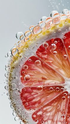 a grapefruit cut in half with bubbles and water on the top, as seen from below