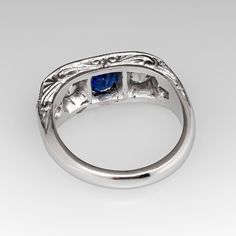 This lovely circa 1930s antique sapphire ring is centered with one (1), bead set, oval cut natural blue sapphire weighing 0.81 carats and flanked to each side by one (1), bead set, old European cut diamond. The shoulders of the ring are each bead set with two (2) round single cut diamonds. The gemstones are bordered with milgrain edging. Engraved details accent the side faces of the ring. The ring measures 7.3mm at the top, rises 3.7mm above the finger, tapering to 2.9mm wide and 1.6mm thick at the base of the shank. The ring is currently a size 6 and we offer complimentary resizing to fit. Elegant Blue Oval Cabochon Signet Ring, Elegant Sapphire Signet Ring, Elegant Sapphire Signet Ring With Gemstone, Elegant Sapphire Gemstone Signet Ring, Classic Oval Sapphire Ring, Classic Sapphire Birthstone Ring, Classic Sapphire Birthstone Ring With Gemstone, Classic Sapphire Halo Ring, Classic Oval Signet Ring With Rose Cut Diamonds