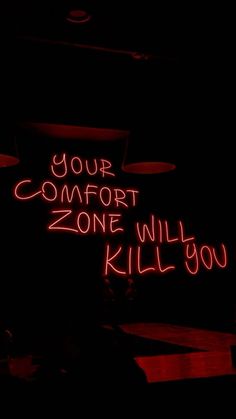 a neon sign that says your comfort zone will kill you