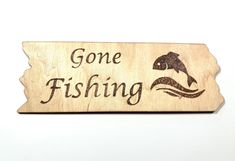 a wooden sign that says gone fishing with a fish in the water on it's side