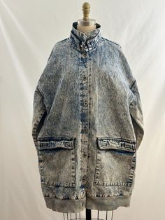 This 90s denim jacket is totally retro. Acid washed, it has a funnel collar, buttons up the front with  oversized pockets, along with side pockets,  flannel lined interior and a midi length. A cool piece to add to your closet. -Vintage 90s  -Midi length, acid washed -Machine wash recommended Measurements:  Marked  one size fits all *Sleeve 23 inches from collar *Bust 26 inches *Length 24 1/2  inches *Bottom opening 21 inches *This item is pre-loved and there may be minor flaws to the garment. Not to worry if there is anything major we will let you know. *minor wear, last button replaced Oversized Washed Denim Outerwear, Oversized Medium Wash Utility Denim Jacket, Oversized Medium Wash Denim Jacket In Utility Style, Oversized Utility Denim Jacket In Medium Wash, Oversized Light Wash Collared Denim Jacket, Oversized Washed Denim Jacket In Medium Wash, Acid Wash Denim Button-up Outerwear, Washed Denim Collared Outerwear, Acid Wash Denim Outerwear With Button Closure