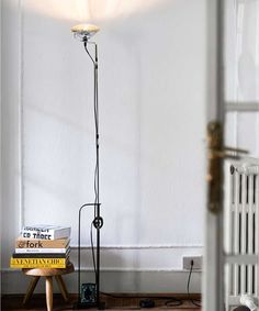 a floor lamp sitting next to a stack of books