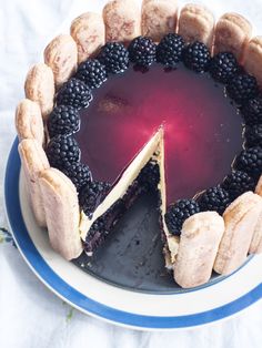 a blue and white plate topped with a cake covered in berries