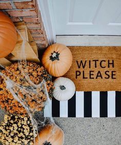 pumpkins and gourds are sitting on the front door mat that says witch please