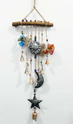 a wind chime hanging from a rope with bells and stars on it's side