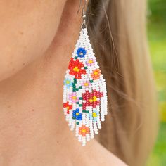 Introducing the Carmen de Viboral Earrings, a stunning homage to the artistry of a charming Colombian town renowned for its exquisite hand-painted china adorned with floral designs. These beautiful earrings feature pristine white beads embellished with vibrant, colorful flower details, all meticulously handwoven with the finest Czech beads. Perfectly capturing the essence of summer, the Carmen de Viboral Earrings add a touch of elegance and warmth to any outfit. Let these exquisite earrings brin Party In A Box, Craft Shop, Czech Beads, Gift Card Shop, Fringe Earrings, White Beads, Floral Designs, Corporate Gifts, Colorful Flowers