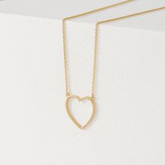 Anabella Follow your heart and it’ll lead you to our 14k gold necklaces. Add a touch of timeless elegance with our delicate Heart Cut-Out Pendant in Solid Gold. This beautiful pendant features a classic heart shape with a modern open center design. Crafted from 14k solid gold (available in yellow, white, or rose gold), this pendant offers long-lasting quality and a luxurious shine. Its versatility makes it perfect for any outfit, and it's a thoughtful gift symbolizing love and affection. - Handm