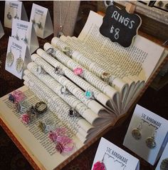 an open book sitting on top of a table filled with jewelry and cards next to each other