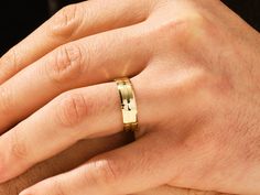 a man's hand with a gold wedding ring on his left and right hand