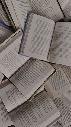 a pile of open books sitting on top of each other