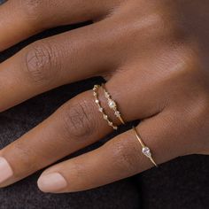 a woman's hand with a gold ring and diamond band on her left wrist