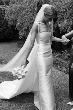 a woman in a wedding dress holding the hand of another woman