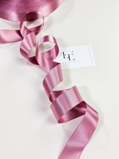 pink satin ribbon on white background with business card