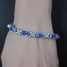 This beautiful estate bracelet is sterling silver with sapphire colored and clear cubic zirconia stones. Measurements: 1/4 of an inch wide, 7 wearable inches Marks: FAS, 925 Condition: Excellent Silver Rhinestone Tennis Bracelet Gift, Silver Rhinestone Bracelets For Anniversary, Silver Diamond Bracelet With Rhinestones For Anniversary, Silver Sterling Silver Bracelet With Rhinestones, Sterling Silver Bracelet With Rhinestones, Silver Bracelets With Rhinestones For Jewelry Making, Hematite Ring, Inlay Jewelry, Purple Jade