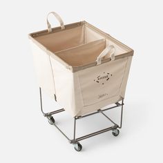 a shopping cart with a canvas bag on the top and handles, sitting upright against a white background