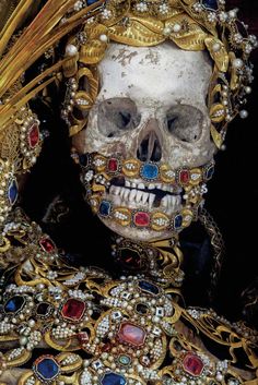 a skull with gold and jewels on it's head