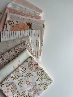 five different fabrics laid out on top of each other, one is pink and the other is white