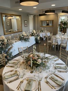 the tables are set with white linens and gold place settings for an elegant wedding reception