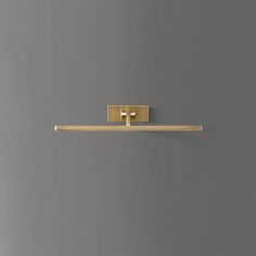 a gold toilet paper holder on a gray wall