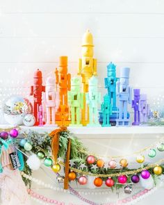 an assortment of colorful christmas decorations on a mantle