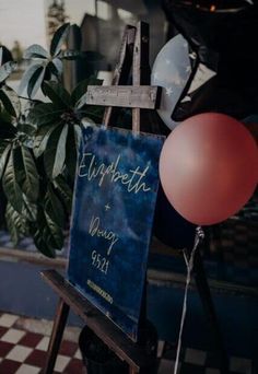 a sign that says elizabeth and vincy is hanging from a ladder next to some balloons