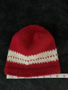 Beautiful red and white winter stocking cap. Hand knit with a wool mix yarn so it will keep your head warm and toasty on cold winter days. This stocking cap has quite a bit of stretch and will comfortably fit most people. Red Knitted Beanie For Winter, Red Knitted Winter Beanie, Red Knit Winter Hat, Cozy Red Knitted Hat, Cozy Red Knitted Beanie, Red Knitted Hat For Cold Weather, Red Knitted Beanie One Size, Red Knitted Beanie (one Size Fits Most), Red Cap For Cold Weather