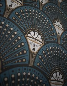 an image of a blue and gold wallpaper with fan design on it's side