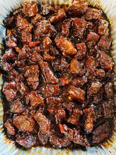 a bowl filled with meat sitting on top of a table