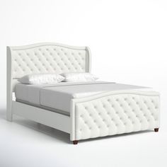 a white bed with an upholstered headboard and foot board on the side