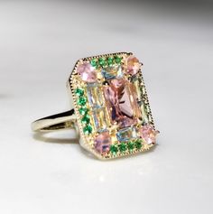 The Emerald Morganite 1930s Era Art Deco Cocktail ring features lab created Morganite, Emerald & Aquamarine gemstones on a vintage rectangle setting. She makes a statement with a mix of fancy gemstone cuts; baguettes, pear cut, radiant cut. The setting is comfortable, low profile and sits flush to the finger. Get ready for compliments! Lab Created Gemstones: Morganite, Emeralds & Sky Blue Topaz Metal: 14k Gold Vermeil (Sterling Silver base) Dimensions: 18mm x 15mm Band Width: 1.8mm Hypoallergeni Art Deco Cocktail, Cute Engagement Rings, Morganite Ring, Classy Jewelry, Jewelry Studio, Jewelry Lookbook, Radiant Cut, Jewelry Inspo, Dream Jewelry