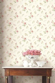 a table with vases and flowers on it in front of a wallpapered background