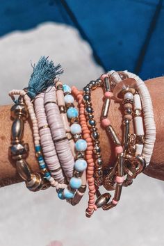 a person's arm with several bracelets on top of it and a tassel hanging from the wrist