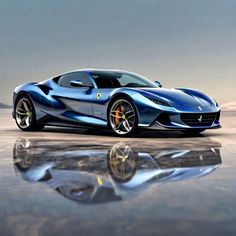 a blue sports car parked on top of a wet ground next to a body of water